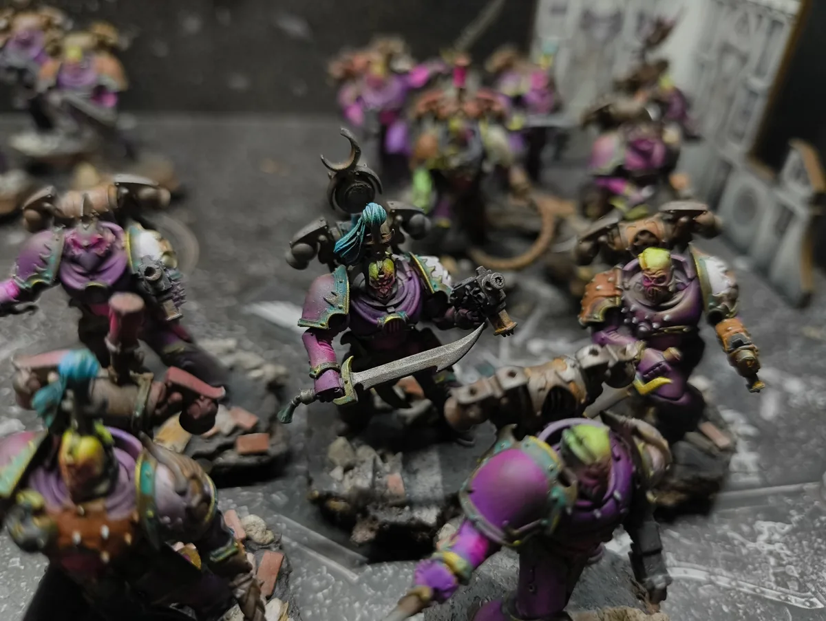 Ejército de Warhammer 40K con armaduras magenta sobre peanas de ruinas